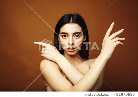 Cute happy young indian woman on brown background in studio close up smiling, fashion beauty warm tanned 91979686