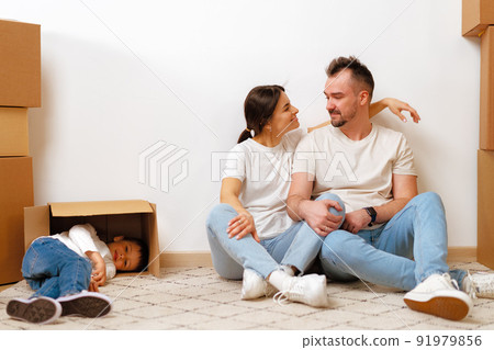 Young parents and son having fun during moving day to new house 91979856