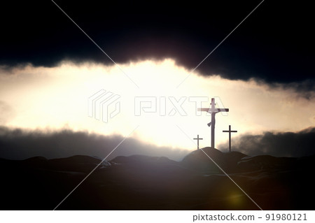 Bright rays of light between the majestic sky and dark clouds and the silhouette and background of the cross of Jesus Christ 91980121