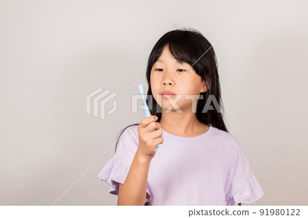 A state of an elementary school girl brushing her teeth A state of an elementary school girl brushing her teeth 91980122