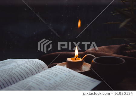 Rain and raindrops falling on the window, candles, crosses and bibles 91980154