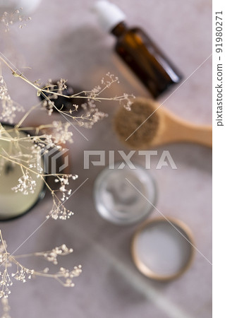 Skin care product for oil face massage and flowers on white table. Selective focus. Eco friendly organic reusable self care accessories. 91980271