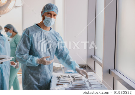 Professional doctor surgeon takes scalpel before surgery in operation room at the hospital 91980552