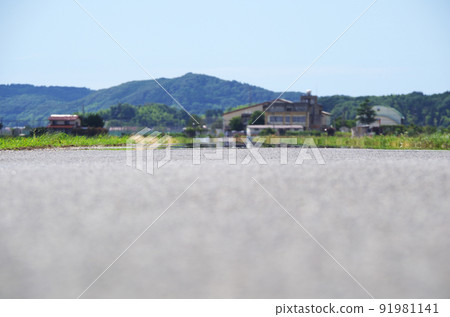 A scene of heat haze on the asphalt road surface under the scorching sun in summer 91981141