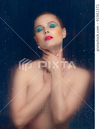 Portrait of beautiful woman with bright makeup posing in underwear isolated over dark blue background. Foggy glass effect 91981371