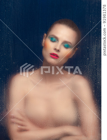 Portrait of beautiful woman with bright makeup posing in underwear isolated over dark blue background. Foggy glass effect Portrait of beautiful woman with bright makeup posing in underwear isolated over dark blue background. Foggy glass effect 91981378