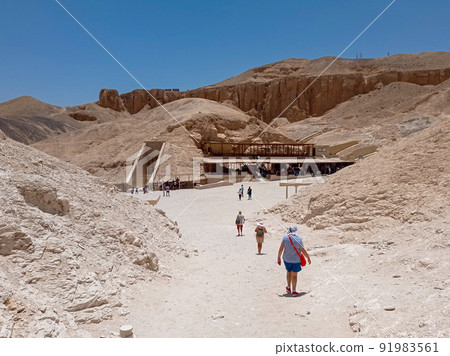 Tourists walking towards a tomb carved on the side of a mountain near Abu Simbel in Egypt 91983561