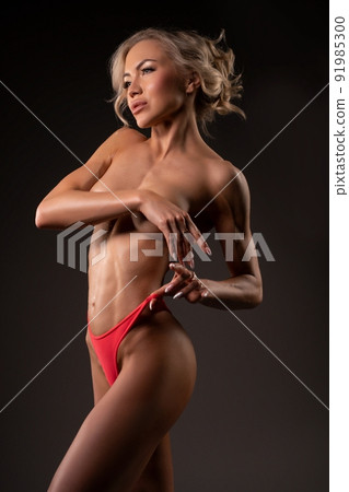 Alluring topless woman standing in modern studio 91985300