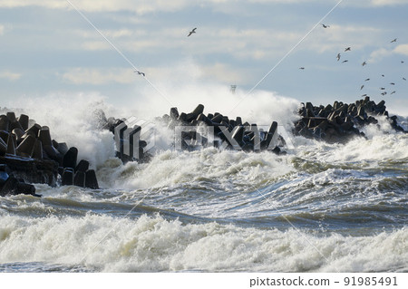 coastal storm in the baltic sea, big waves crash against the harbor breakwater coastal storm in the baltic sea, big waves crash against the harbor breakwater 91985491