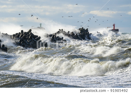 Waves crash on a breakwater during winter storms Waves crash on a breakwater during winter storms 91985492