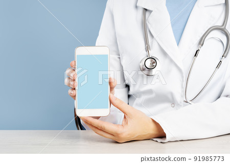 Doctor holding a mockup smartphone with an medical app Doctor holding a mockup smartphone with an medical app 91985773