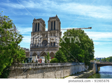 Paris, France. June 2022. Nice view of the Notre Dame facade from the bridge over the Seine. The crane of the restoration site is visible after the great fire that damaged the cathedral. Paris, France. June 2022. Nice view of the Notre Dame facade from the bridge over the Seine. The crane of the restoration site is visible after the great fire that damaged the cathedral. 91985876