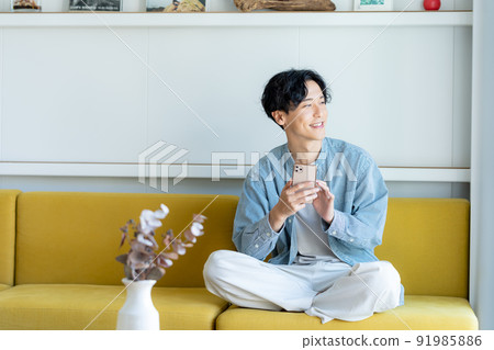 A young man operating a smartphone A young man operating a smartphone 91985886