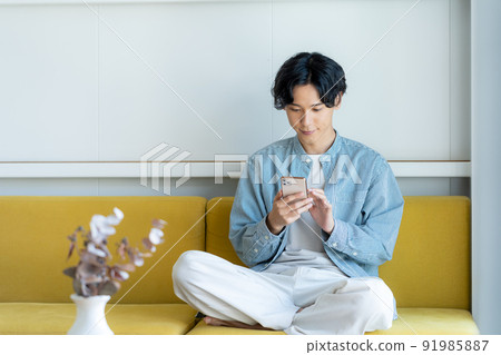 A young man operating a smartphone A young man operating a smartphone 91985887
