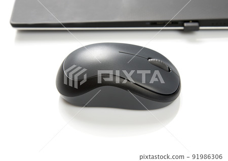 Computer wireless mouse next to a laptop on a white table close-up. electronic personal industry Computer wireless mouse next to a laptop on a white table close-up. electronic personal industry 91986306