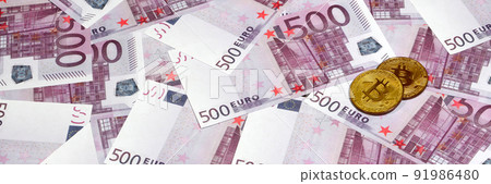 Bitcoins over pile of five hundred euro banknotes. Traditional money versus cryptocurrency concept. Gold coin above 500 euro bills. Close up 91986480