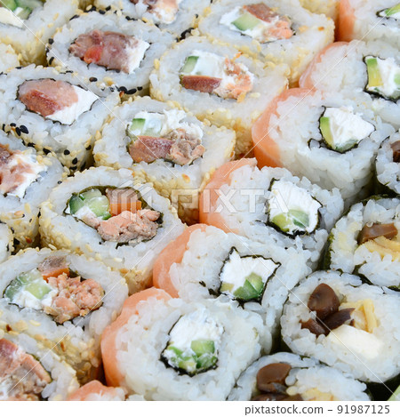 Close-up of a lot of sushi rolls with different fillings. Macro shot of cooked classic Japanese food. Background image Close-up of a lot of sushi rolls with different fillings. Macro shot of cooked classic Japanese food. Background image 91987125