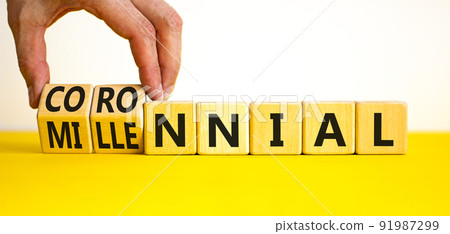 Millennial or coronnial symbol. Doctor turns wooden cubes and changes the concept word Millennial to Coronnial. Beautiful yellow table white background. Millennial or coronnial concept. Copy space. 91987299