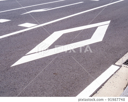 在路面上畫的鑽石標記。道路標記(指示標記)“與人行橫道或自行車道口”。 在路面上畫的鑽石標記。道路標記(指示標記)“與人行橫道或自行車道口”。 91987748