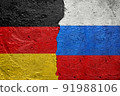 Germany vs Russia - Cracked concrete wall painted with a Germans flag on the left and a Russian flag on the right stock photo 91988106