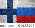 Finland vs Russia - Cracked concrete wall painted with a Finlandian flag on the left and a Russian flag on the right stock photo 91988108