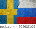 Sweden vs Russia - Cracked concrete wall painted with a Swedish flag on the left and a Russian flag on the right stock photo 91988109