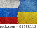 Russia vs Ukraine - Cracked concrete wall painted with a Ukrainian flag on the left and a Russian flag on the right stock photo 91988112
