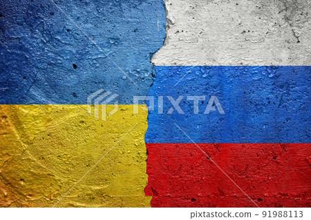 Russia vs Ukraine - Cracked concrete wall painted with a Ukrainian flag on the left and a Russian flag on the right stock photo 91988113