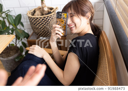 Cute woman shooting with a smartphone Cute woman shooting with a smartphone 91988473