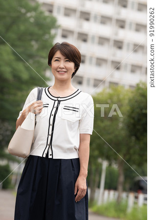 Middle Japanese business woman walking in a residential area 91990262