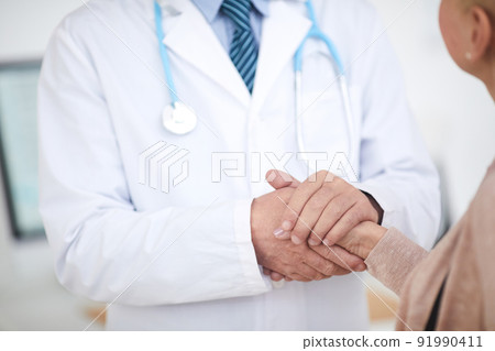 Close-up of unrecognizable male doctor in lab coat standing and holding hand of patient while supporting her Close-up of unrecognizable male doctor in lab coat standing and holding hand of patient while supporting her 91990411