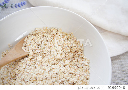 Thin flake-shaped oatmeal [instant oats] _12 served in a white bowl 91990948