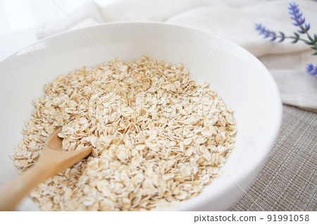 Thin flake-shaped oatmeal [instant oats] _22 served in a white bowl 91991058