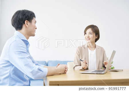 Saleswoman talking to a client in the living room 91991777