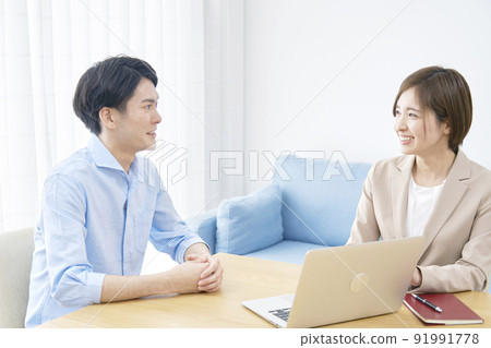 Saleswoman talking to a client in the living room 91991778