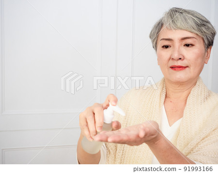 Portrait of mature asian woman 50s holds a white bottle with a cosmetic product. Portrait of mature asian woman 50s holds a white bottle with a cosmetic product. 91993166