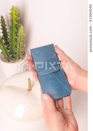 blue leather pen case for two pen in human hands closeup photo on white interior background blue leather pen case for two pen in human hands closeup photo on white interior background 91994040