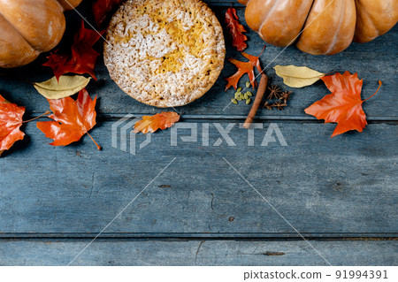 Composition of autumn leaves, pumpkins, spices and pie on wooden background 91994391