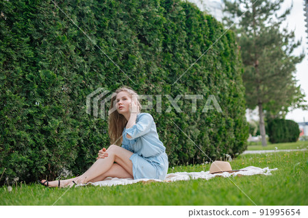Romantic girl with hat on picnic in park Romantic girl with hat on picnic in park 91995654