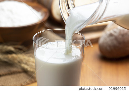 Milk and lots of bread in a glass on a wooden table Milk and lots of bread in a glass on a wooden table 91996015