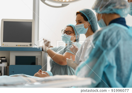 Concentrated professional surgical team working with a patient in an operation room 91996077