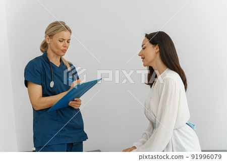 Therapist conducts a preventive examination of a woman in her office in a modern clinic 91996079