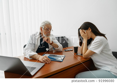 Upset patient after hearing diagnosis disease listens medical worker in hospital office Upset patient after hearing diagnosis disease listens medical worker in hospital office 91996080