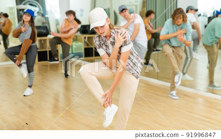 Teen girl dancing krump in choreographic studio with teenagers Teen girl dancing krump in choreographic studio with teenagers 91996847