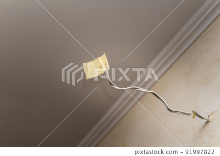 Close-up of an insulated power cable on the wall of an apartment. Close-up of an insulated power cable on the wall of an apartment. 91997822