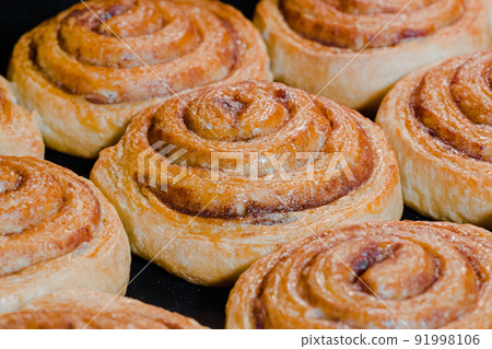 Baked homemade cinnamon buns in electric oven - close up 91998106