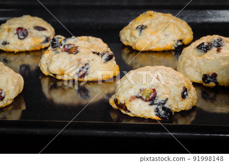 Cooking yellow oatmeal raisin cookies on metal sheet: close up Cooking yellow oatmeal raisin cookies on metal sheet: close up 91998148