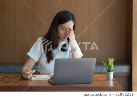 Image of Young woman stressed whlie exam online on laptop computer. studying or working from home online concept. Image of Young woman stressed whlie exam online on laptop computer. studying or working from home online concept. 91998231