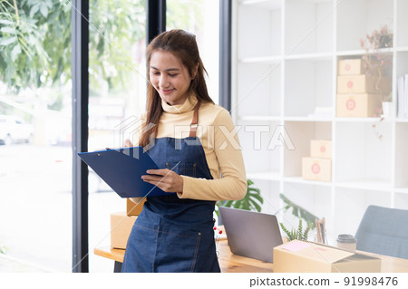 Asian small business owner working at home office. Business retail market and online sell marketing delivery, SME e-commerce concept. Asian small business owner working at home office. Business retail market and online sell marketing delivery, SME e-commerce concept. 91998476