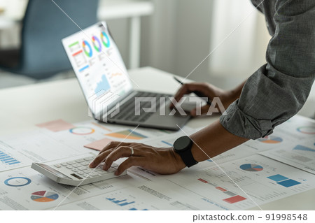 Consult financial concept. Businessman pointing at paperwork and using calculator on desk at office. back to office. Consult financial concept. Businessman pointing at paperwork and using calculator on desk at office. back to office. 91998548
